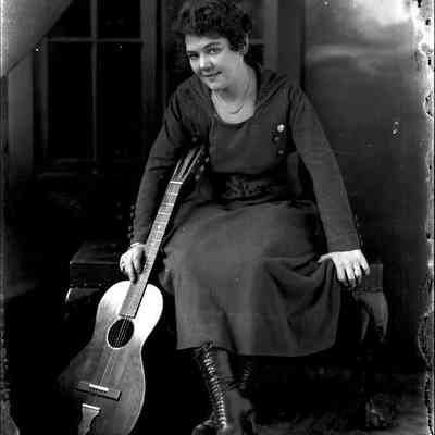 Unidentified female, seated, guitar on her left side, glass-plate negative