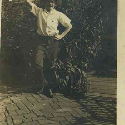 Unidentified Young Man Standing if Front of a Bush