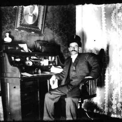  male; he is sitting in a wooden swivel chair