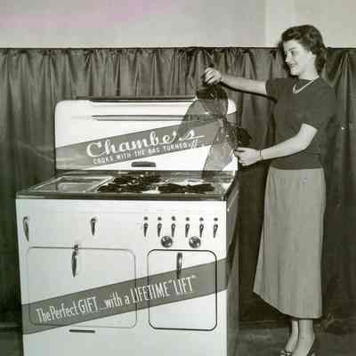unidentified woman with display of a Chambers Range wrapped in gift ribbon