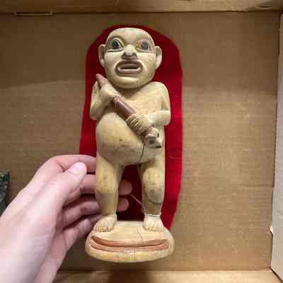 Wood carving man holding fish club