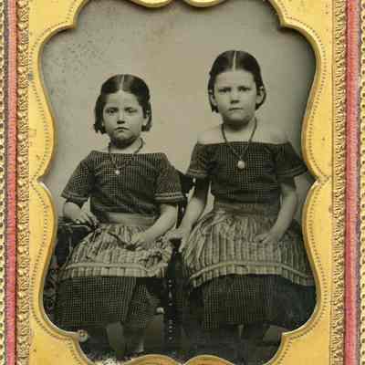 Sisters in Matching Outfits with Aprons