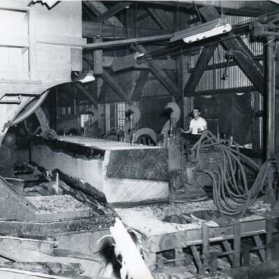 Photo of a log being squared for cutiing as it enters the mill