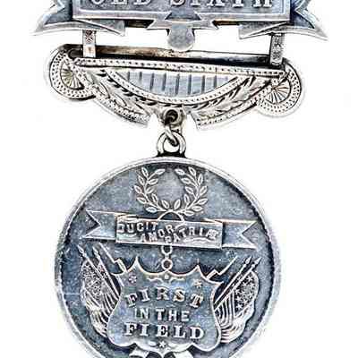 The image features a silver medal labeled "OLD SIXTH" with detailed engravings and ornamentation.