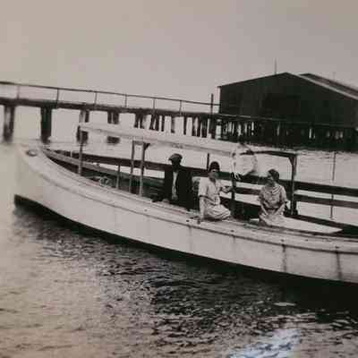 Pleasure boat with 3 people on board at the wharf.