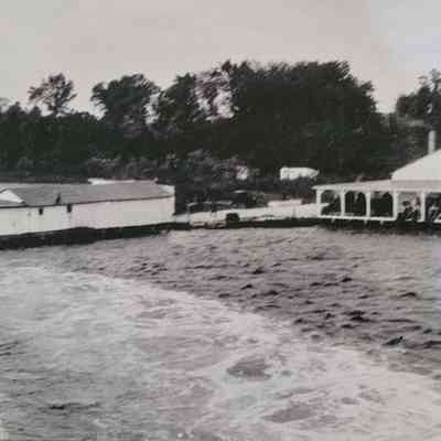 View from steamboat leaving wharf. Wharf is on left and cannery on right.