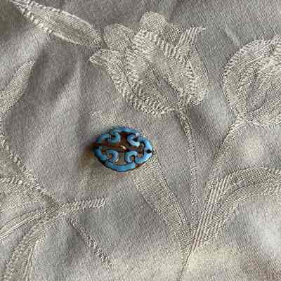 Oval shaped metal and blue brooch