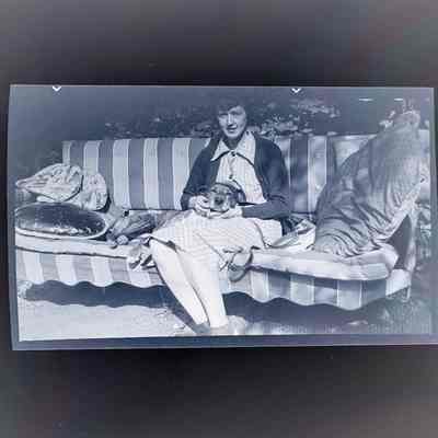 Negative of Emma Cohen Bray holding a dog on her lap