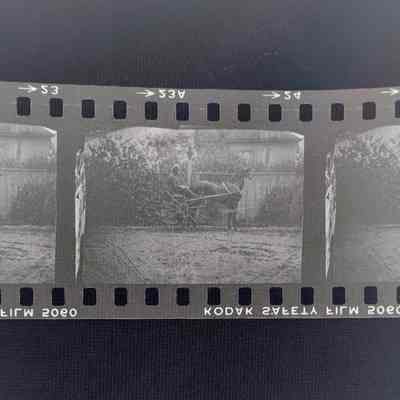 Negative of man on a horse carriage