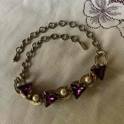 Gold tone chain necklace with purple gems and pearls