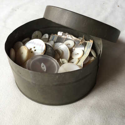 White buttons in round metal container.