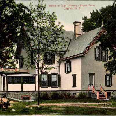 Home of Supt. Murray brook. Farm. Chester, N.Y. Front chs-019947-2: The image depicts the residence of Superintendent Murray at Brook Farm in Chester, New York. This charming two-story home features a white exterior with green shutters, a steeply pitched roof with decorative trim, and a stone foundation. A sunroom with large windows and a flat roof is attached to the back of the house. Surrounded by lush foliage and mature trees, the setting conveys a serene, pastoral atmosphere, emphasized by the grassy lawn and clear sky above. The aged nature of the image, indicated by its colorization and style, suggests it is a historical postcard, capturing a moment from the past in detailed color.