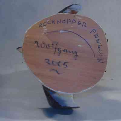 Rockhopper Penguin - bottom: The image showcases the base of an object labeled "ROCKHOPPER PENGUIN" with handwritten elements including "Wolfgang" and the year "2005."