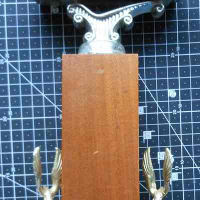 Charter Member Leander Keeney Trophy back: The image shows a vintage car trophy with a wooden base, featuring two golden eagle figures.