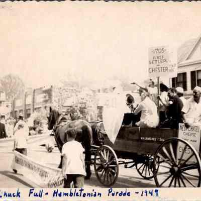 Chuck Full - Hambletonian Parade - 1949: The photo captures a horse-drawn wagon with people carrying signs that depict some of Chester's history; 1705 - First Settler, Chester first-only Orange County town to publish a history, Neuchatel Cheese first made in Chester.