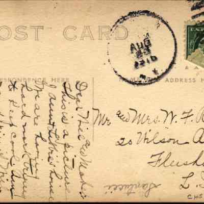 Address side on the "Aunt Libbie’s House" poscard: The image shows a vintage postcard featuring a postmark dated August 23, 1910 and a one-cent U.S. postage stamp. The left side of the card contains densely written cursive handwriting designated for correspondence, while the right side is reserved for the recipient's address, clearly marked to Mr. and Mrs. W. F. Rea of Wilson Ave., Flushing, L. I. The card embodies the charm of early 20th-century personal communication.