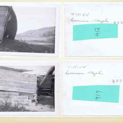Baird Farm after Hurricane Hazel: The image features a pair of black and white photographs showing the aftermath of Hurricane Hazel, dated 10-15-54. The top left photo depicts a damaged wooden structure, slightly tilted, with a scenic view of a distant hill and open field. The right side shows a handwritten note with the date, "Hurricane Hazel," and partially obscured text due to a green label. The bottom left photograph captures another angle of a wooden building, set upon a foundation of concrete blocks, visibly showing signs of structural impact. To the right, a similar note is present, along with another green label, partially covering the text.