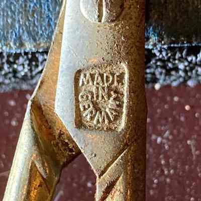 Ear & Nose Hair Trimming Scissors - County of Origin mark.: The image shows a close-up of rusted ear & nose hair trimming scissors, revealing the “Made in Germany” mark.