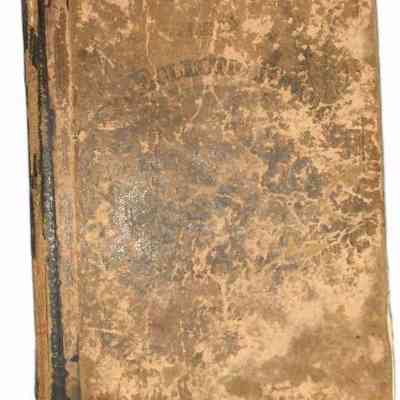 McGuffey's Third Eclectic Reader cover: An old, weathered book with a worn brown cover shows visible signs of aging and extensive use.
