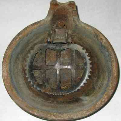 Jamesway dairy cow water bowl - top view: The image shows a water stained, circular metal object with a grid-patterned cow-operated valve panel inside and labeled "Jamesway."