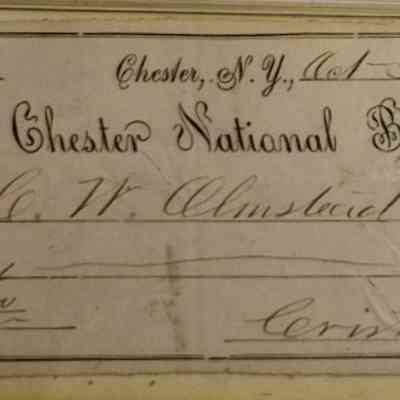 Olmstead Side A: The image shows an old handwritten bank draft from October 31, 1883, issued by The Chester National Bank in Chester, New York. It is made out to C.W. Olmstead or bearer, specifying the amount of six dollars. The draft includes ornate, flowing script with decorative elements, such as intricate bordering on the left side. Various fields are filled in with cursive handwriting, denoting the date, the recipient's name, and the amount both in numerals and words. There is also a signature at the bottom right corner labeled as "Crist & Son." The entire document exhibits a vintage quality, reflecting the banking practices of the late 19th century, with its formal writing style and aesthetic presentation, highlighting the historical context in which it was issued and the careful artistry of official financial documentation during that period.