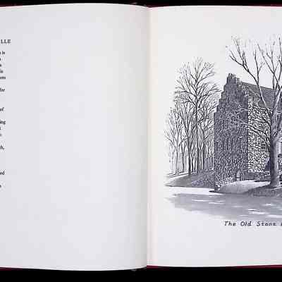 The image shows an open book with a descriptive text on the left page about the Brotherhood Winery in Washingtonville, New York, highlighting its status as the oldest continuously operating winery in the United States since 1839. The right page features a detailed black and white illustration of the Old Stone Building at the Brotherhood Winery, depicting the historic structure made of stone, surrounded by bare trees and a clear sky, conveying a serene and historical atmosphere. The artwork captures the solid, timeless architecture of the building, enhancing its historical significance as described in the text.