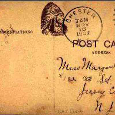 Address side of the."St. Columba Church and Rectory" postcard: This image displays an old postcard, postmarked from Chester, N. Y. on November 19, 1907. It features a green one-cent Benjamin Franklin stamp in the top right corner. The card is addressed to Miss Margaret Curtin of Jersey City, New Jersey, and showcases a printed Artino logo image of a Native American in profile. Handwritten script details the recipient’s address and a message, making the card a historical artifact that captures a moment of personal communication from the early 20th century