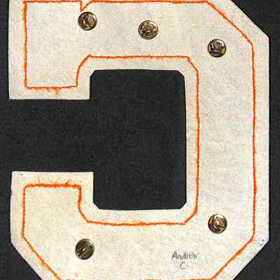 Andrew Cavallero Varsity Basketball & Soccer Letter reverse: The image shows the reverse of a letter "C" patch with orange stitching and metal rivets on a black background.