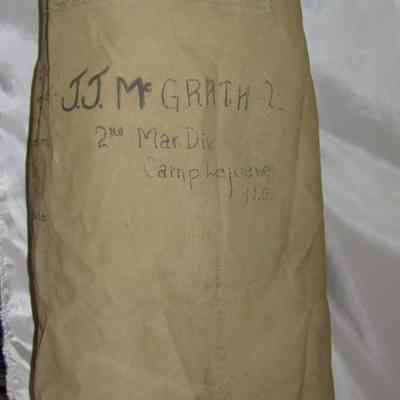 John J. McGrath's Duffel Bag: A brown military bag displays handwritten details, including a name and location, Camp Lejeune, North Carolina.