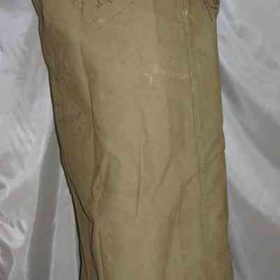 John J. McGrath's Duffel Bag: The image shows a large, beige, canvas sack with handwriting, standing upright.