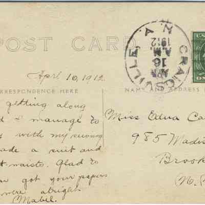 Address side of the "Ruins of the Craigville Wagon Makers Shop" postcard.: The image shows a vintage postcard dated April 16, 1912, with a handwritten message and a one-cent U.S. postage stamp featuring Benjamin Franklin. The card’s postmark is clearly visible, and it is addressed to Miss Edna Comday in Brooklyn, New York. The written message indicates that the sender, Mabel, is doing well, keeping busy with sewing, having made a suit and two shirtwaists. Mabel expresses happiness about receiving papers from Edna.