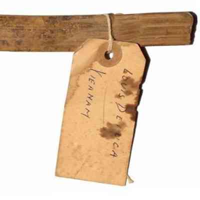 Vietnam Punji stick_dorsal side: The image shows a large, aged wooden stake with an attached handwritten tag and color calibration chart.