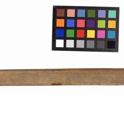 ietnam Punji stick_ventral side: The image shows a large, aged wooden stake with an attached handwritten tag and color calibration chart.