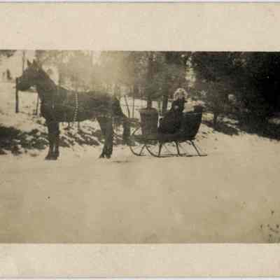 Woman with girl in one horse sleigh