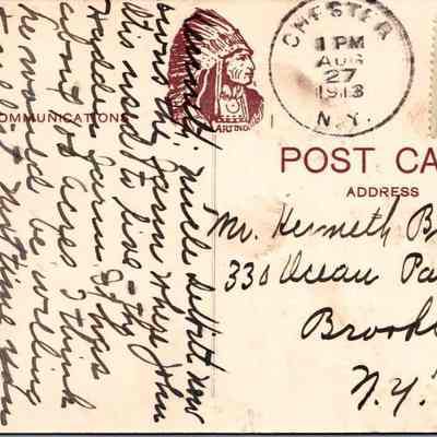 “Chester, N.Y. The Farmers Domain” Back chs-019950-8: The image displays a vintage postcard, postmarked August 27, 1913, from Chester, New York. It features a 1-cent U.S. postage stamp and a clear red ink stamp with a Native American chief's profile labeled "ARTOIS". The postcard is addressed to Mr. Kenneth Bainbridge at a location in Brooklyn, New York. The left side of the postcard is filled with handwritten cursive script that covers the entire space, obscuring any possible image or design that might be underneath, except for a watermark-like design overhead with the word "COMMUNICATION" in capitals. The handwriting appears densely packed and rushed, suggesting a personal and possibly detailed message.