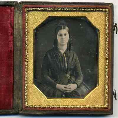 Seated lady with tinted cheeks and gold necklace