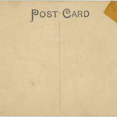 Address side of the "Howland House, Chester, N. Y." postcard.: The image depicts an aged, blank postcard showcasing a vertical dividing line, with the word "POST CARD" prominently displayed at the top in bold, black lettering. On the left side, there's a small black circle stamp labeled "Excelsior N.Y. (Leipzig Dresden Berlin)," logo of The American News Company in New York. The top right corner has a faded, partially torn, with a box for a stamp indicating postage rates: "United States and Island Possessions, Cuba, Canada, …
