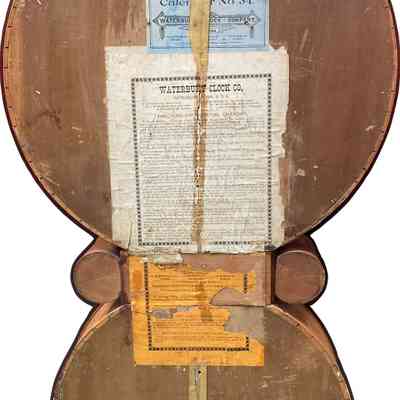 Waterbury Clock-Calendar #34 - back: The image shows the backside of a wooden clock case with various labels attached.