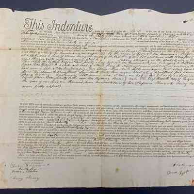 Asa Byram and wife Joann to Jacob Schultz 1805 Land Deed - Front: The image depicts an old legal document titled "This Indenture," written in a formal script and detailing an agreement between several parties. The paper has a pre-printed section with blank spaces where specific information has been handwritten. The text is densely packed, covering rights, obligations, and the transfer of property or land. Signatures of the involved parties and witnesses are present at the bottom, with notable names like Isaac Shipman and others inked, some with wax seals. The document shows signs of aging, with visible creases, yellowing, and slight tears along the edges.