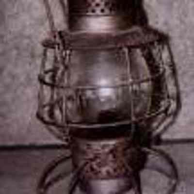 Dietz #39 Vulcan Kerosene Lantern - N.Y.N.H.&H.R.R.: The image shows a vintage Dietz #39 Vulcan Kerosene Lantern - N.Y.N.H.&H.R.R. with a protective wire frame and a curved handle on top.