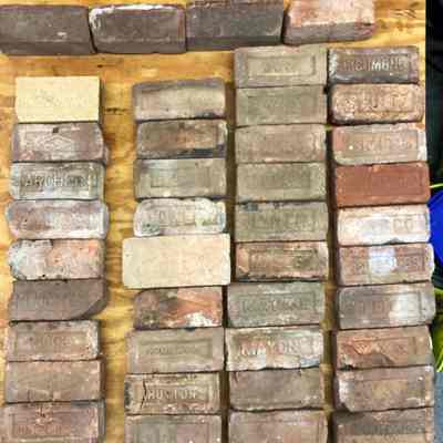 Dale Talemadge's brick collection: The image shows a collection of variously labeled bricks organized neatly on a wooden surface.