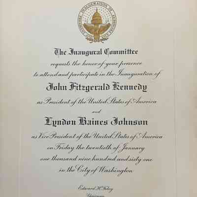 The image shows an official invitation from The Inaugural Committee, embellished with elegant calligraphy and a gold embossed seal of the U.S. Capitol, for the inauguration of John Fitzgerald Kennedy as President and Lyndon Baines Johnson as Vice President of the United States of America. The event is scheduled for Friday, January 20, 1961, taking place in the city of Washington. The text of the invitation requests the honor of the recipient's presence and participation in the ceremony. At the bottom, the name Edward H. Foley appears, identified as the Chairman of the committee, lending an air of formality and importance to the historical occasion being witnessed.