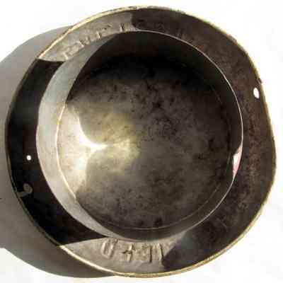 Sheffield Farms milk can lid - bottom view: The image shows the underside of a metallic milk can lid lying on a white background, casting a shadow.