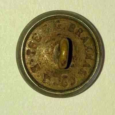 P" Brass Button back: The image shows the back of a vintage, worn button with a loop shank, featuring engraved text around its edge.