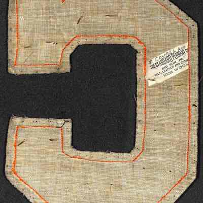 Johnny Cavallero's JV & Varsity Football and Basketball Letter reverse: The image shows back side of a vintage letterman patch shaped as a "C," made of textured fabric.
