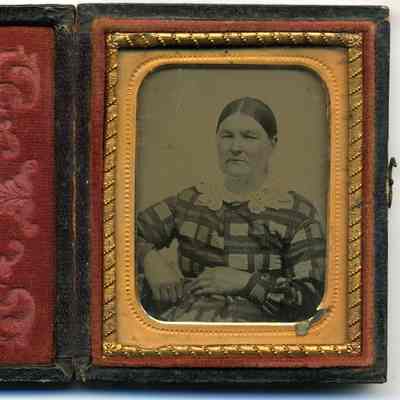 Seated lady, wearing a geometrically patterned dress.