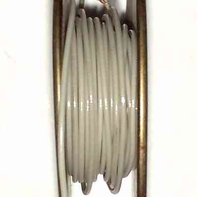 Insulated Wire Spool. Chester Cable Corp. - on end: A spool of white wire is tightly wound around a metal wheel for storage and use.