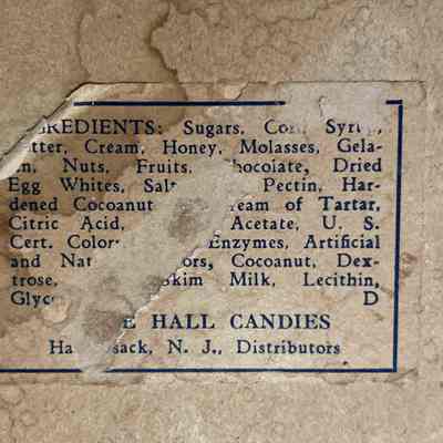 Marie Hall Candies Box - Label.: The image shows a worn candy label listing various ingredients and "Marie Hall Candies" distributor information in faded text.