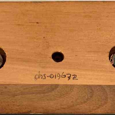 Chart Member Chester Volunteer Ambulance Corp - Henry Lutjens - Bottom: The image shows the bottom of a golden ambulance trophy - a wooden block with three circular holes is shown, featuring a handwritten identification number beneath.