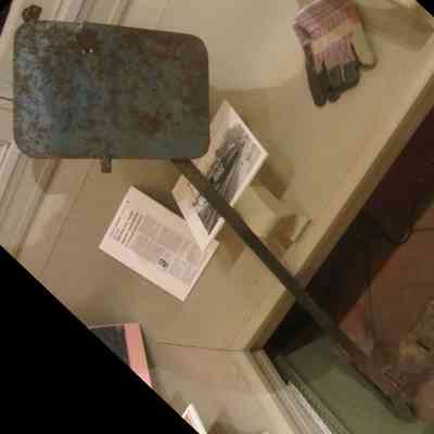 Blue Flag Lockout: The image shows a rusted, blue metal railroad lockout safety device displayed alongside gloves and historical documents.